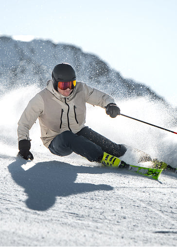 Skier in a light jacket carving on the slope